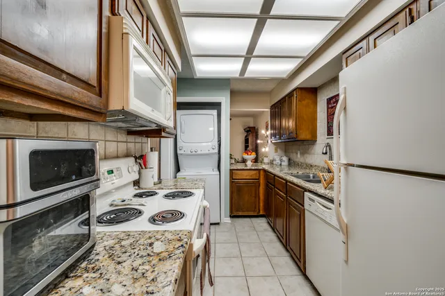 a kitchen with stainless steel appliances kitchen island granite countertop a stove a sink and a refrigerator