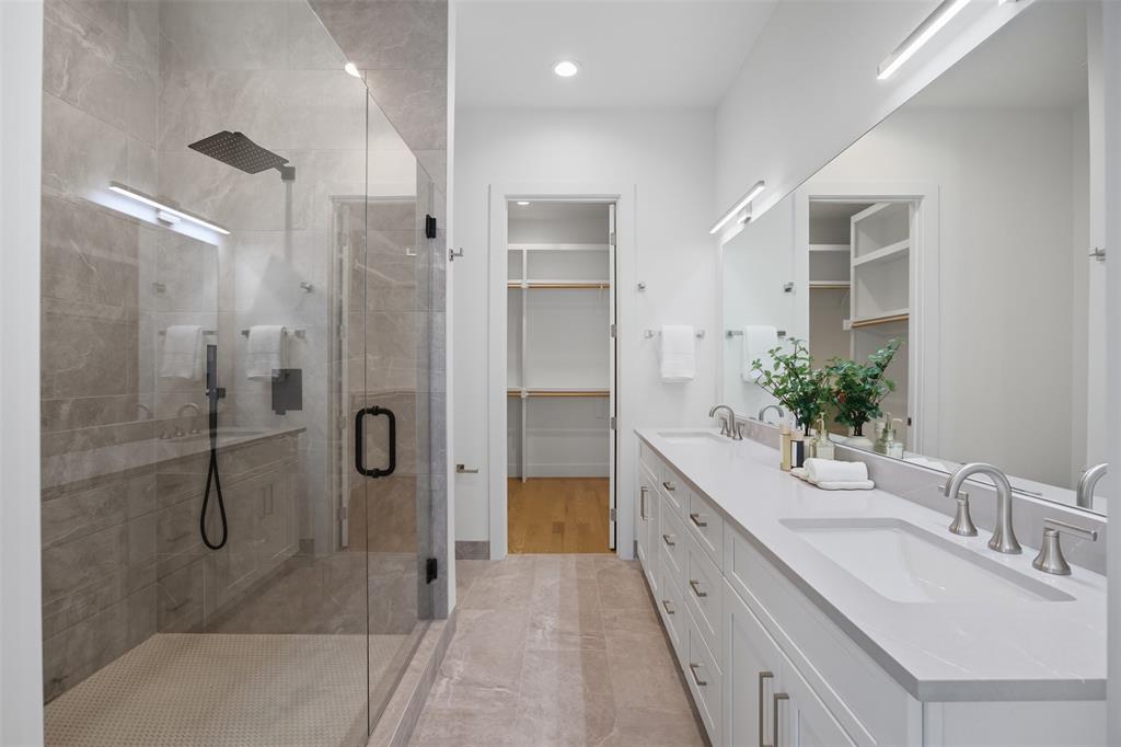 4517 Munger Avenue, Unit 101 Dallas, TX 75204 - Photo 15 of 39 a spacious bathroom with a double vanity sink a large mirror and shower