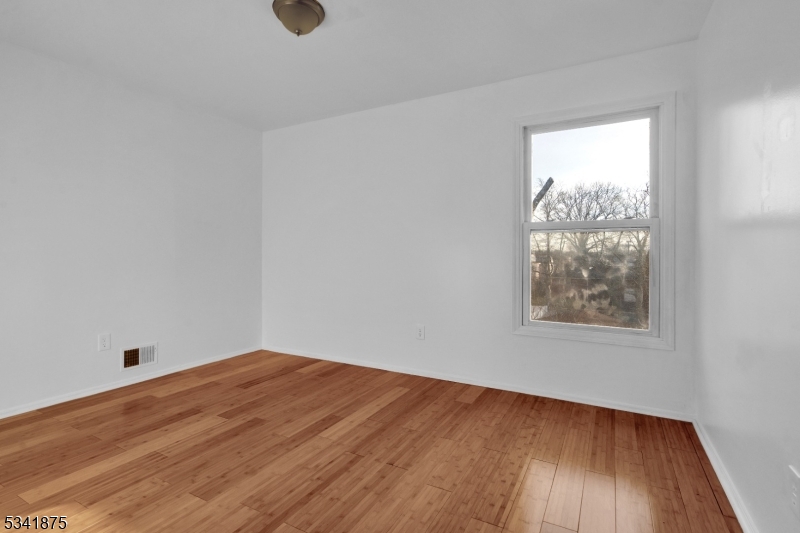 1129 Spruce Street Roselle, NJ 07203 - Photo 11 of 18 an empty room with wooden floor and windows
