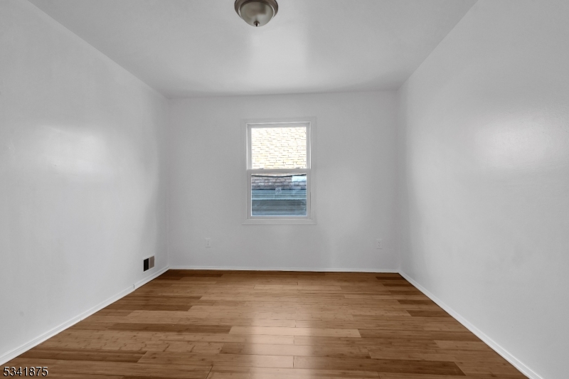 1129 Spruce Street Roselle, NJ 07203 - Photo 15 of 18 an empty room with wooden floor and windows