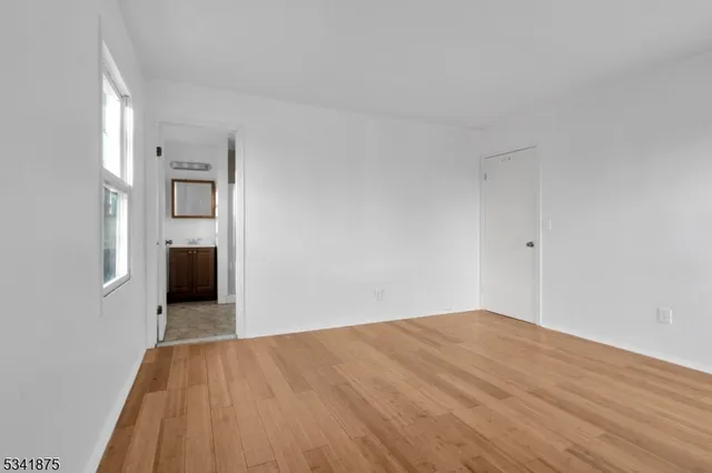 a view of a big room with wooden floor and a ceiling fan