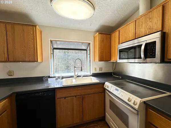 a kitchen with stainless steel appliances granite countertop a sink and a stove