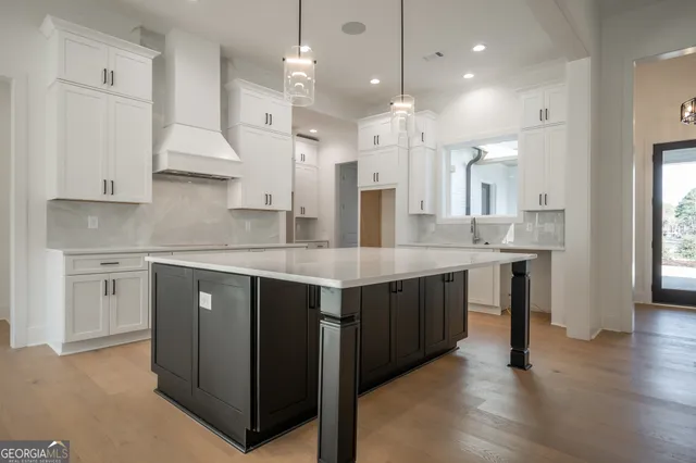 a large kitchen with stainless steel appliances a sink and a refrigerator