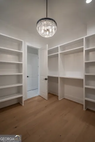 an empty room with wooden floor and a ceiling fan