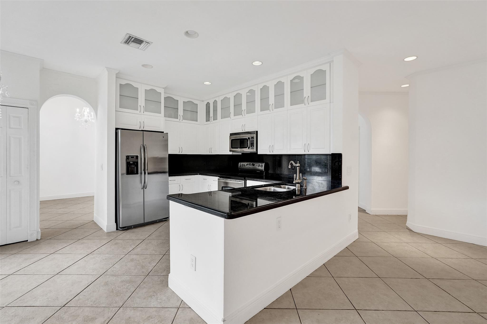 10902 Tamoron Lane Boca Raton, FL 33498 - Photo 15 of 66 a kitchen with granite countertop a sink and a refrigerator