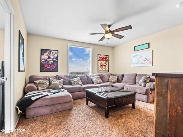 a living room with furniture ceiling fan and a rug