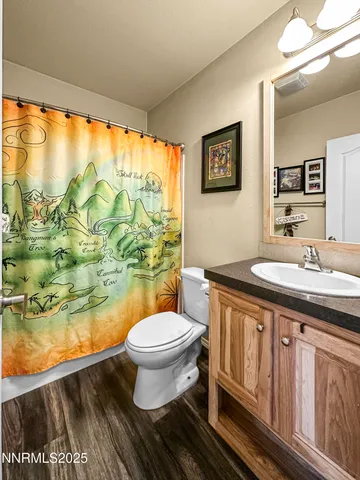 a bathroom with a granite countertop sink toilet and a large mirror