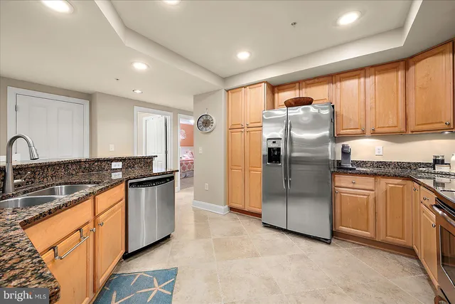 a kitchen with stainless steel appliances granite countertop a refrigerator stove and sink