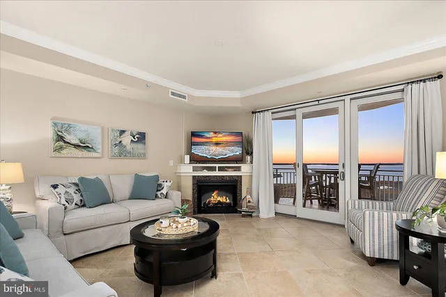 a living room with furniture a fireplace and a large window