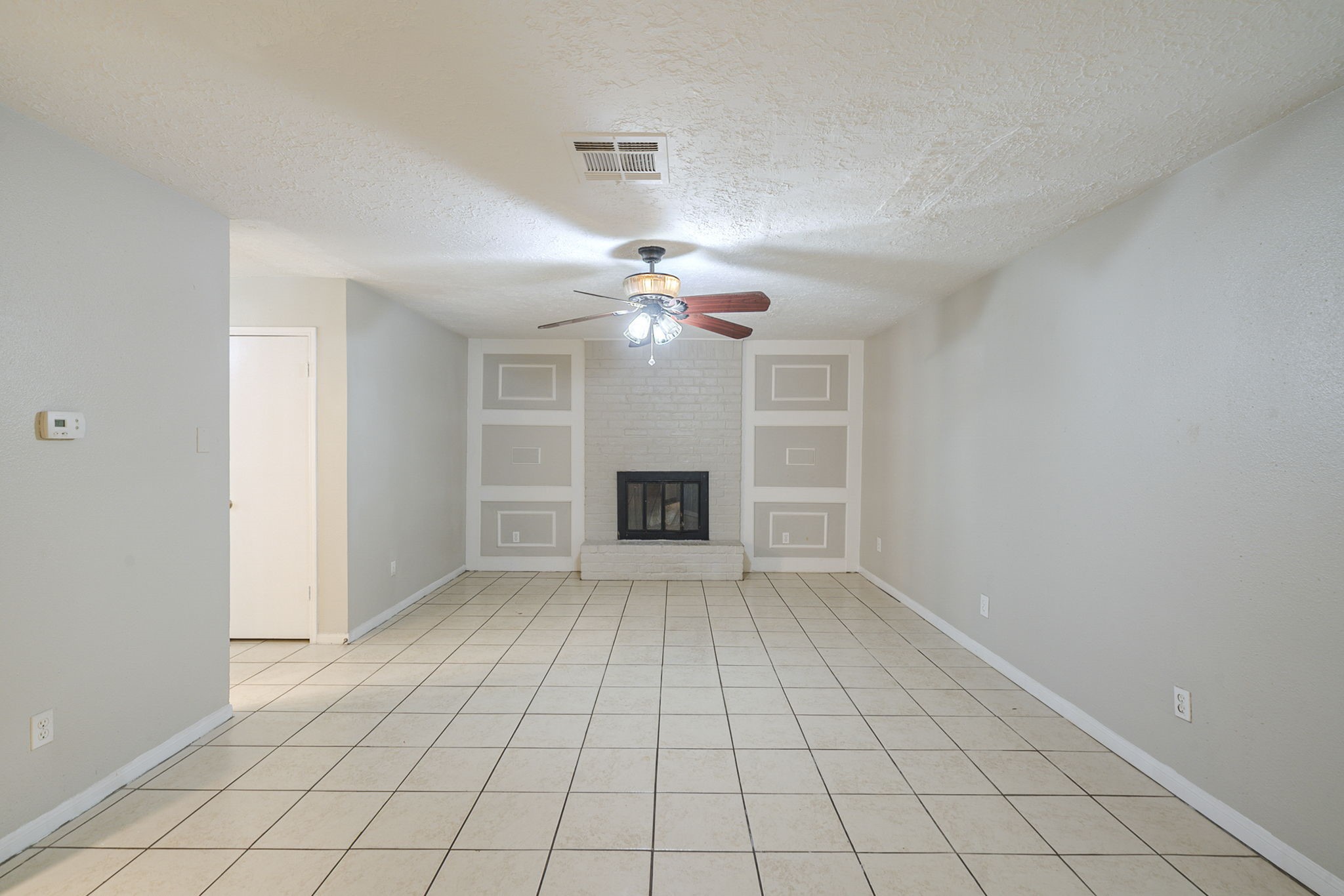 5023 Glendower Drive Spring, TX 77373 - Photo 12 of 33 a view of an empty room with a fireplace and a chandelier fan