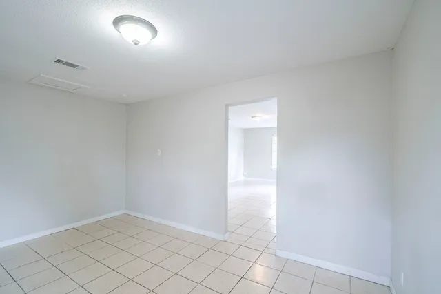 an empty room with white walls and tiles
