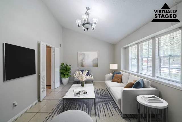 a living room with furniture a flat screen tv and a large window
