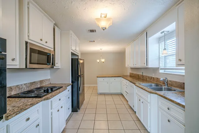 a kitchen with a sink stove top oven and cabinets