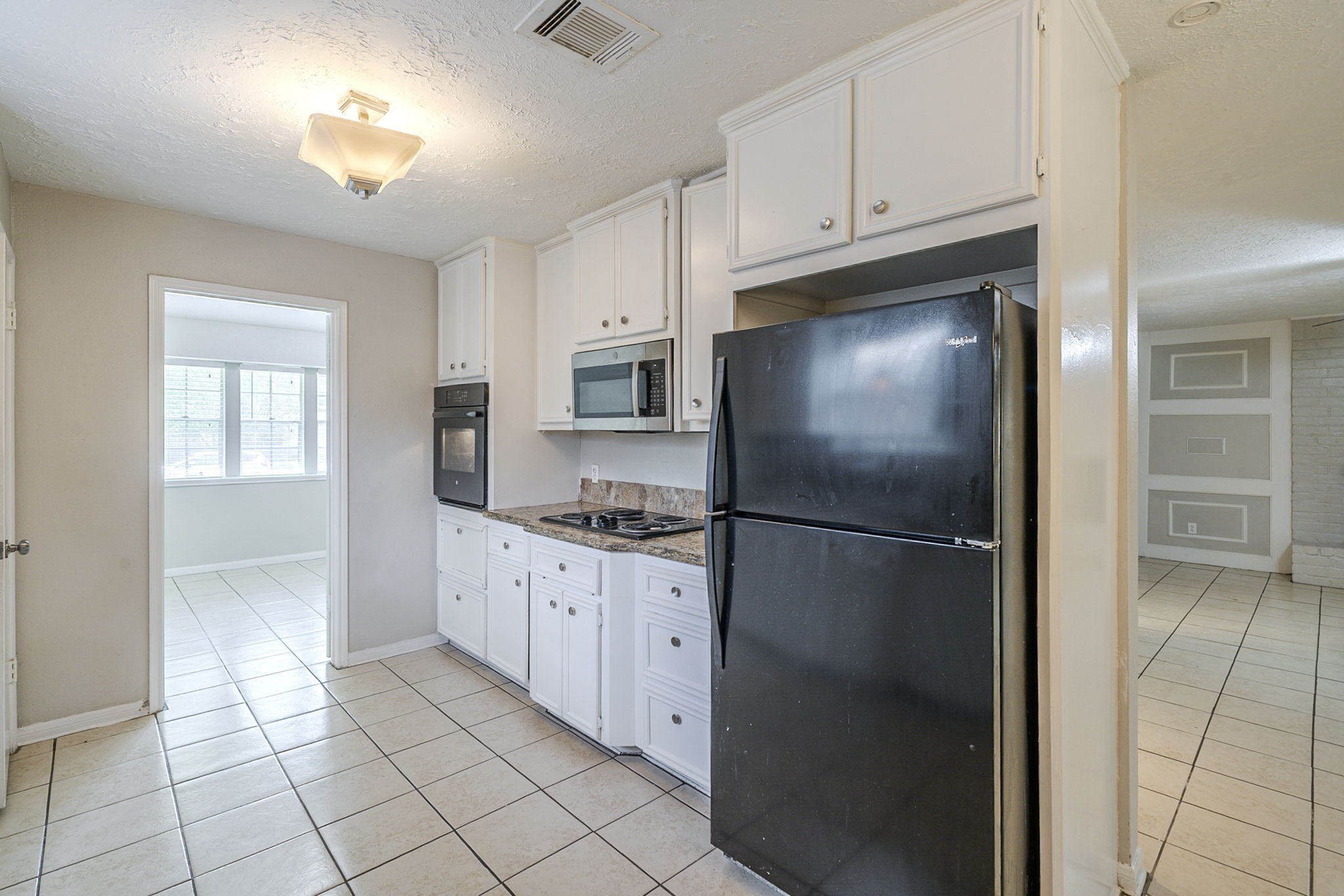 5023 Glendower Drive Spring, TX 77373 - Photo 9 of 33 a kitchen with stainless steel appliances granite countertop a refrigerator a sink and white cabinets