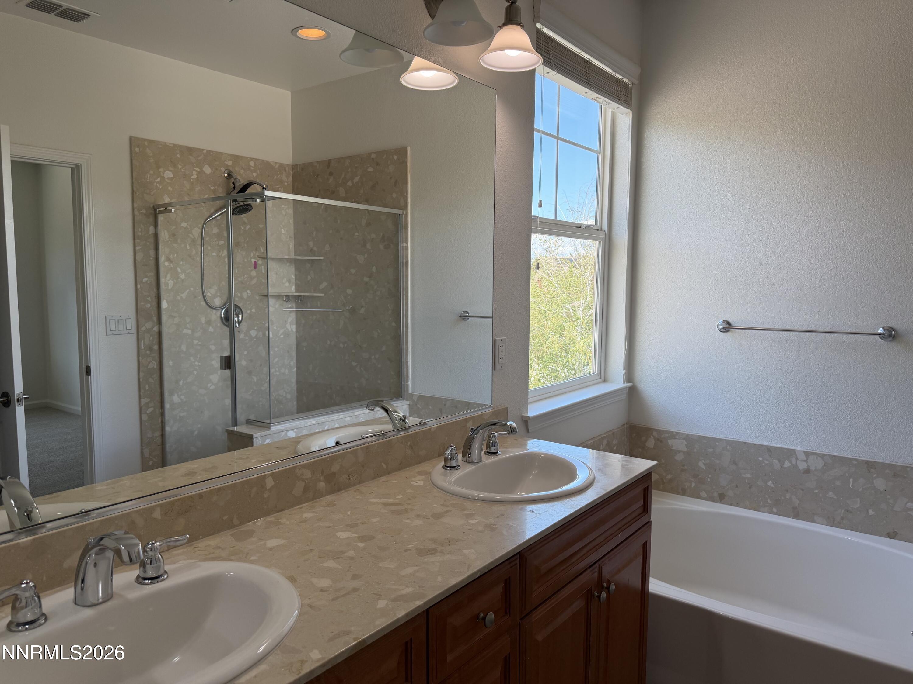 10890 Oakhaven Drive Reno, NV 89521 - Photo 12 of 28 a bathroom with a granite countertop sink mirror and a bathtub