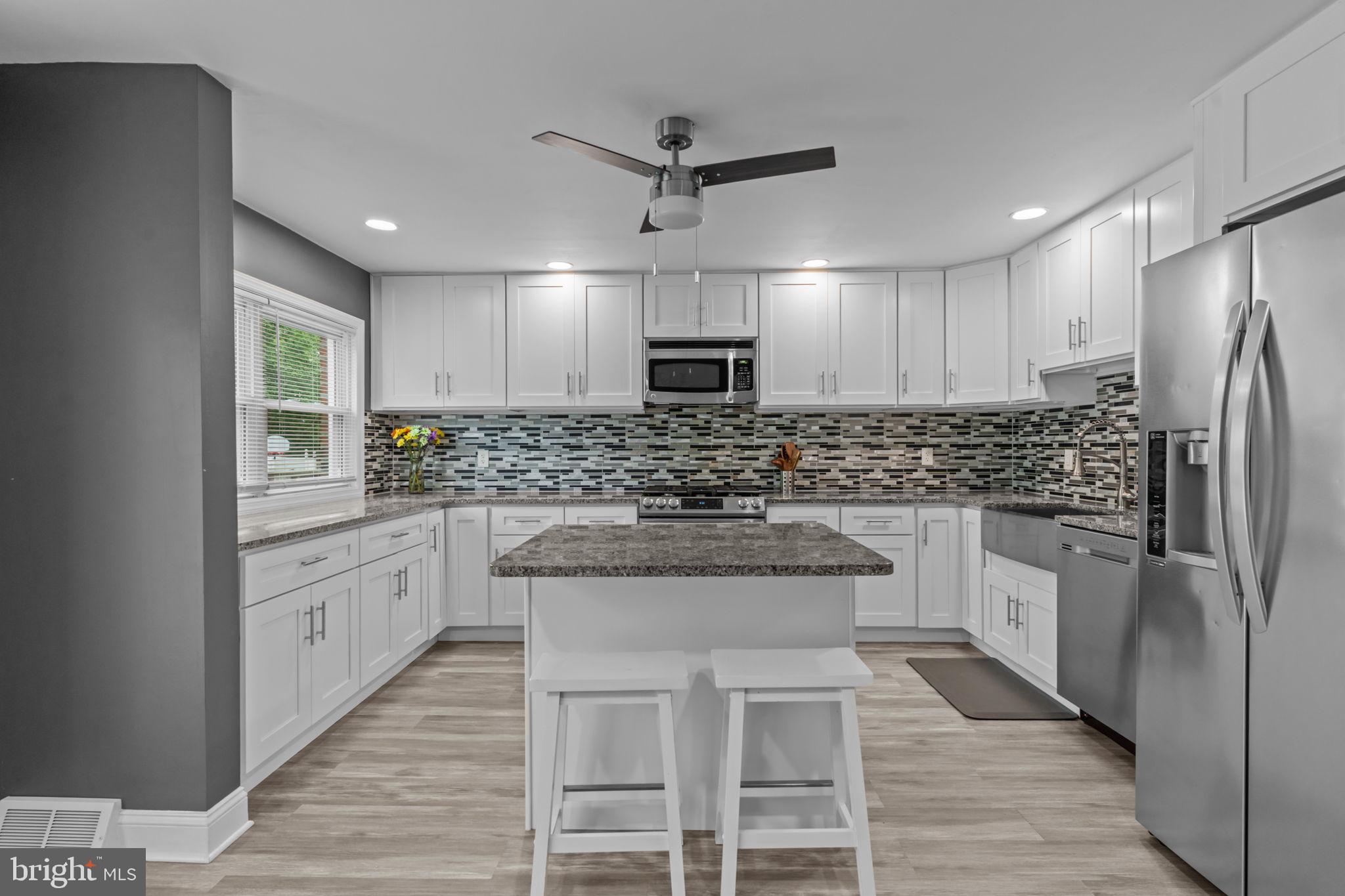 12413 Barbary Road Philadelphia, PA 19154 - Photo 11 of 29 a kitchen with white cabinets and stainless steel appliances