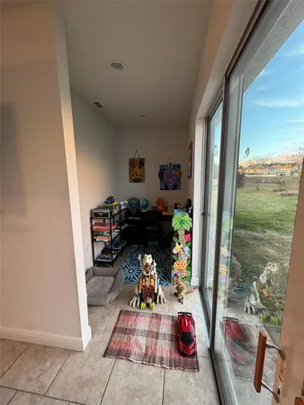 a living room with furniture a floor to ceiling window and a flat screen tv