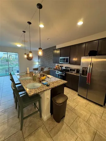 a kitchen with kitchen island a counter space a sink appliances and cabinets