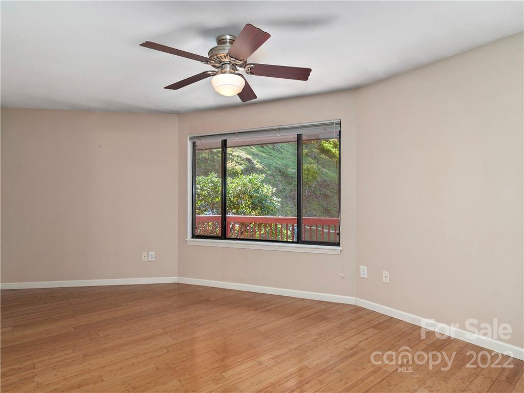 850 Mt Valley Road Waynesville, NC 28785 - Photo 14 of 22 an empty room with wooden floor and windows