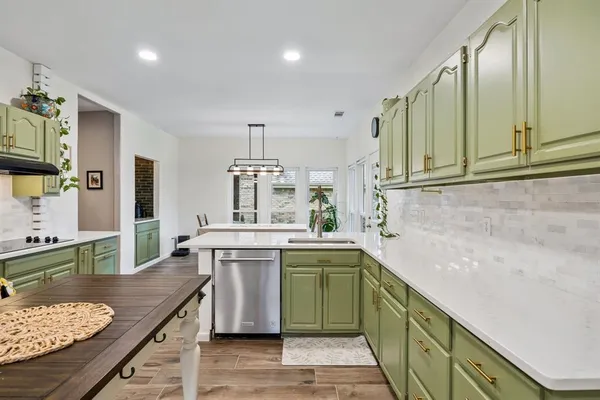 a kitchen with kitchen island a sink stove and cabinets