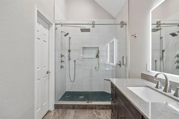 a bathroom with a granite countertop sink shower and a mirror