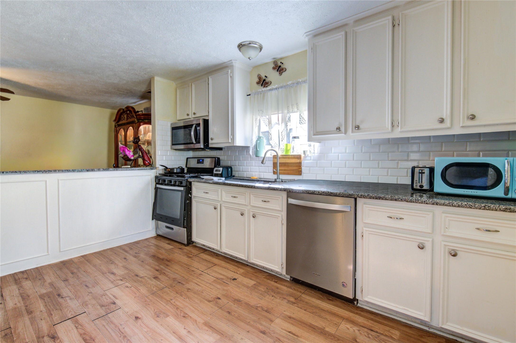 1219 Pilot Point Drive Houston, TX 77038 - Photo 7 of 19 a kitchen with granite countertop white cabinets and white appliances