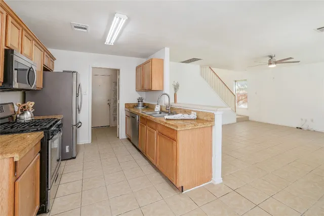 a kitchen with stainless steel appliances granite countertop a stove a sink and a refrigerator
