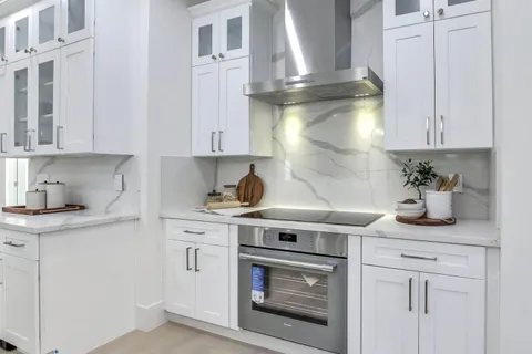 a kitchen with stainless steel appliances granite countertop a sink a stove and cabinets