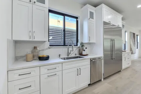 a kitchen with stainless steel appliances white cabinets and a sink