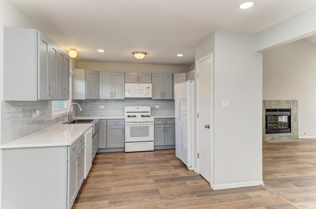 381 Pearson Circle Naperville, IL 60563 - Photo 39 of 43 a kitchen with stainless steel appliances sink cabinets and wooden floor