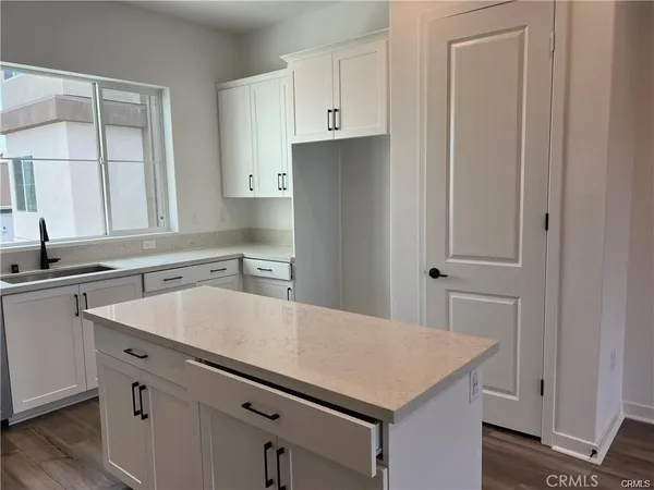 a kitchen with a sink dishwasher and a refrigerator with wooden cabinets