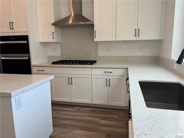 a kitchen with granite countertop white cabinets and black appliances