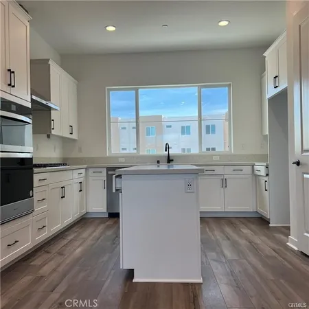a kitchen with a sink window and cabinets