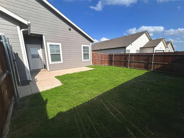 a backyard of a house with wooden floor and fence