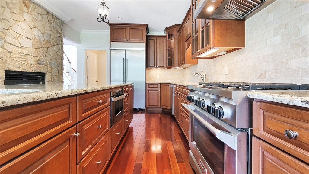 4 Quinns Way, Unit 4 Mashpee, MA 02649 - Photo 12 of 29 a kitchen with wooden cabinets and a stove top oven