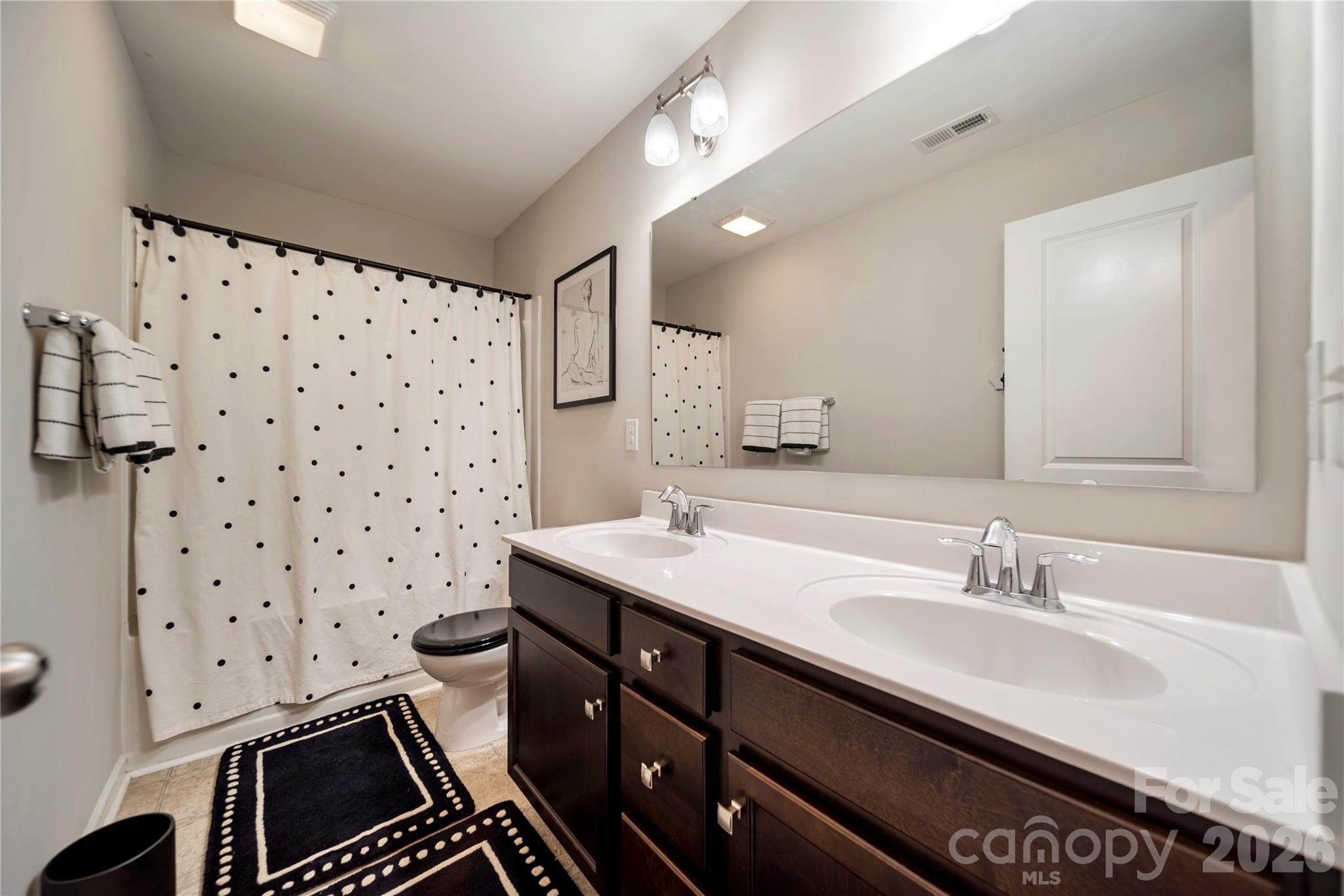 8122 Mossy Rock Road Waxhaw, NC 28173 - Photo 23 of 28 a bathroom with a sink a toilet a mirror and shower