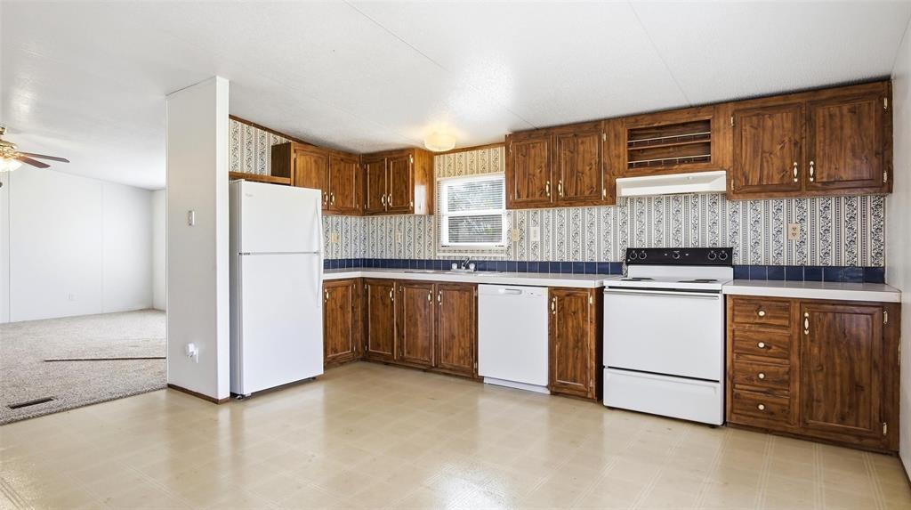 10902 County Road 414 Merkel, TX 79536 - Photo 13 of 26 a kitchen with granite countertop cabinets and white appliances
