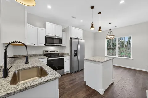 a kitchen with a sink a stove a microwave and refrigerator