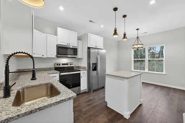 a kitchen with a sink a stove a microwave and refrigerator