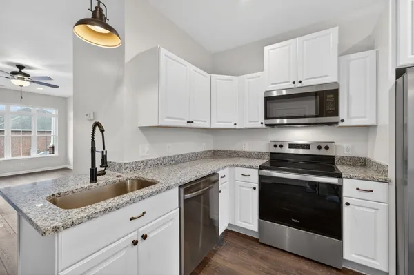 a kitchen with stainless steel appliances granite countertop a sink stove a microwave and cabinets