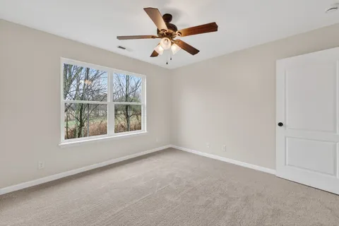 an empty room with window ceiling fan and windows