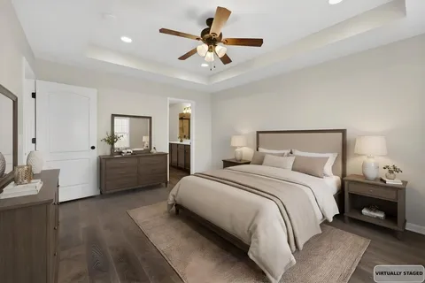 a bedroom with a bed a couches and a chandelier