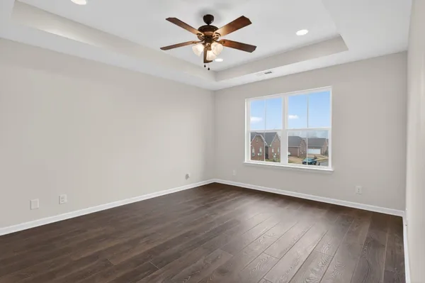 a view of an empty room with window and wooden floor