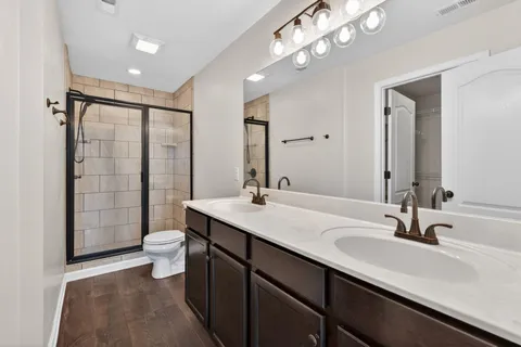 a bathroom with a double vanity sink toilet and shower