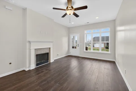 a view of an empty room with a fireplace and a window