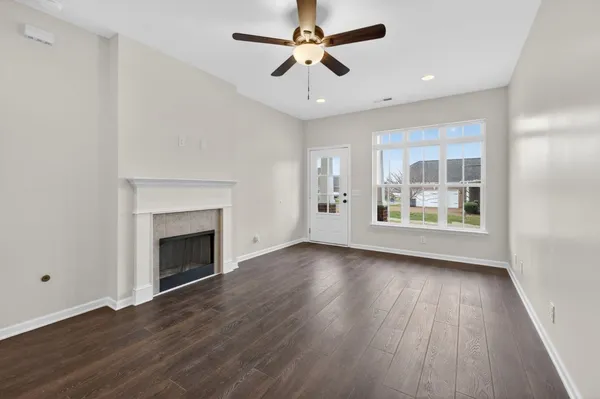 a view of an empty room with a fireplace and a window