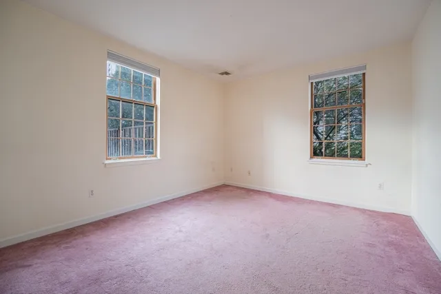 an empty room with windows and closet