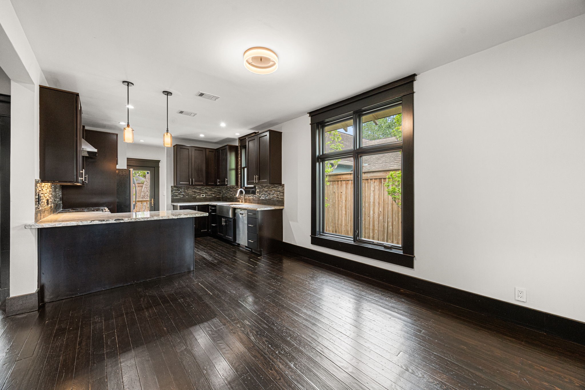 1115 Adele Street Houston, TX 77009 - Photo 7 of 19 Kitchen with large island, granite countertops, and pendant lighting overlooking living space.