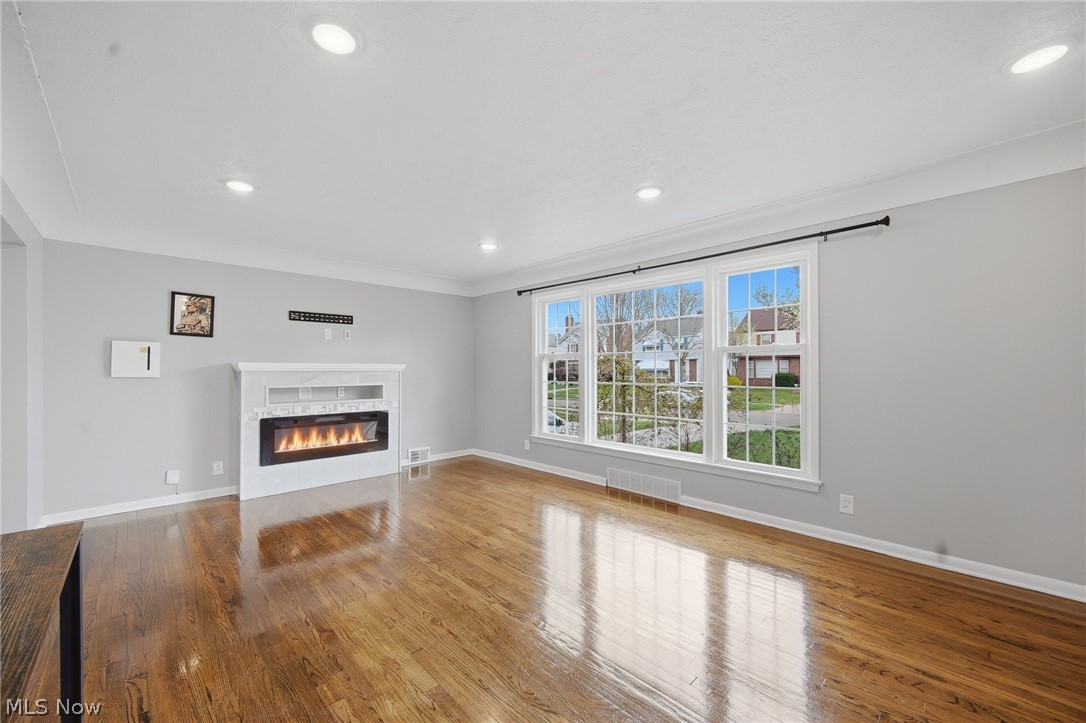 3722 Lindholm Road Shaker Heights, OH 44120 - Photo 8 of 34 Living area featuring hardwood floors, a white fireplace with an electric insert, large windows, and recessed lighting
