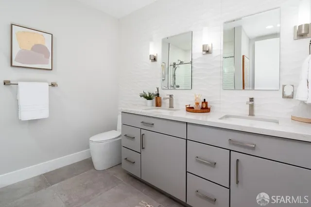 a bathroom with a granite countertop sink a toilet and shower